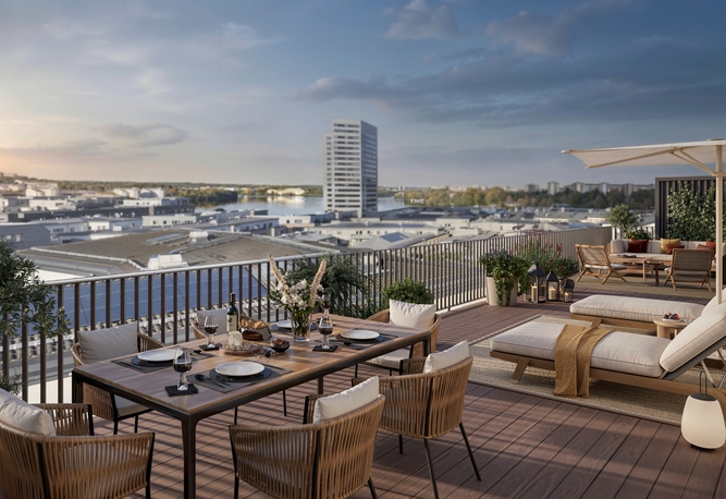 House of Nelly. Takterrass med matbord, solstolar och utsikt över Hornsbergs strand under en delvis molnig himmel i solnedgången.