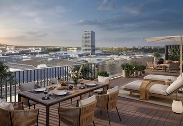 House of Nelly. Takterrass med matbord, solstolar och utsikt över Hornsbergs strand under en delvis molnig himmel i solnedgången.