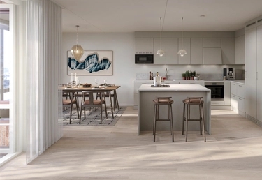 House of Nelly. Modernt kök med köksö, två barstolar, pendellampor och intilliggande matplats med bord och stolar.