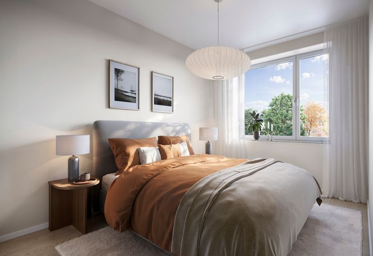 Sovrum med dubbelsäng och stort fönster