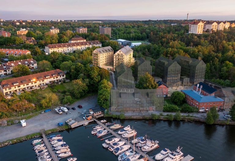 Flygfoto över en småbåtshamn med båtar som ligger nära bostadshus