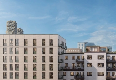 Modernt flerfamiljshus med rektangulära fönster och balkonger under en klarblå himmel; stadsbild i bakgrunden.