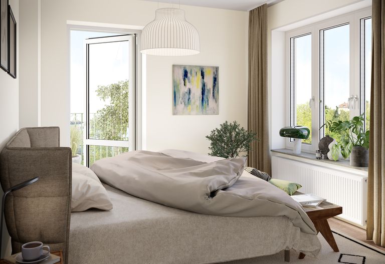 Sovrum med en säng, naturligt ljus som strömmar genom fönstret