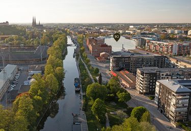 Flygbild över Fyrisån i Uppsala. Till höger i bild är ett nytt bostadskvarter markerat.
