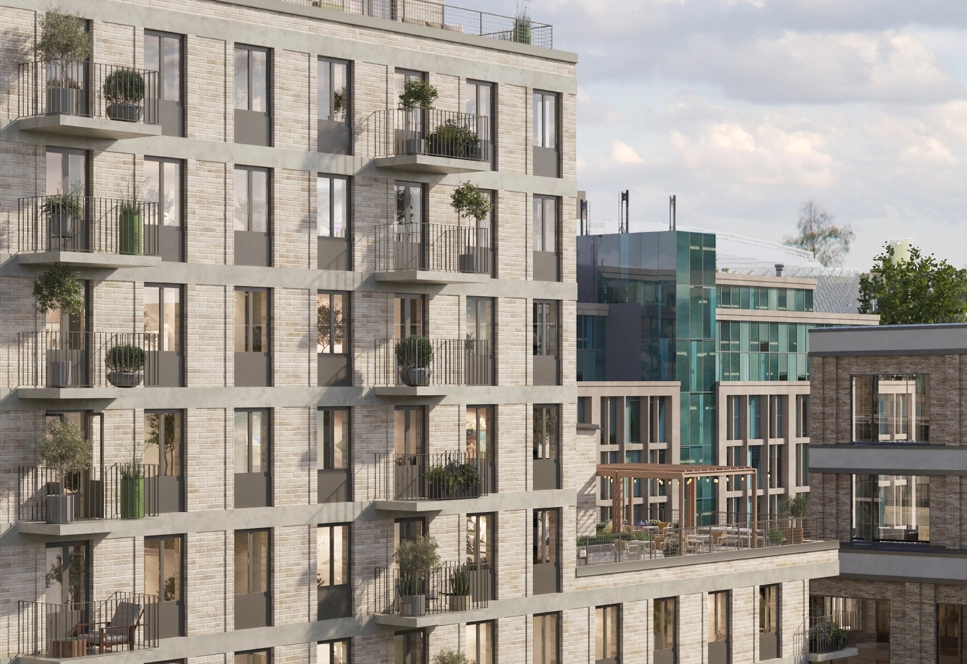 Modernt bostadshus med ljus fasad och balkonger fyllda med grönska. Bakom skymtar andra moderna byggnader och himlen.
