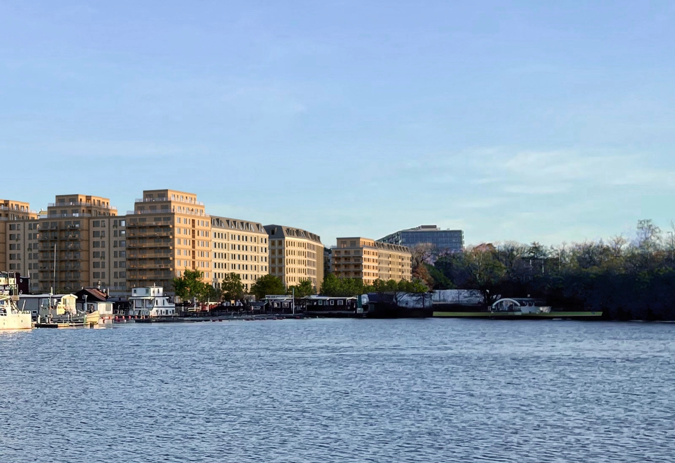 Ett nybyggt bostadsområde längs med en strandkant sett från vattnet