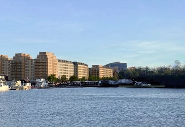 Ett nybyggt bostadsområde längs med en strandkant sett från vattnet