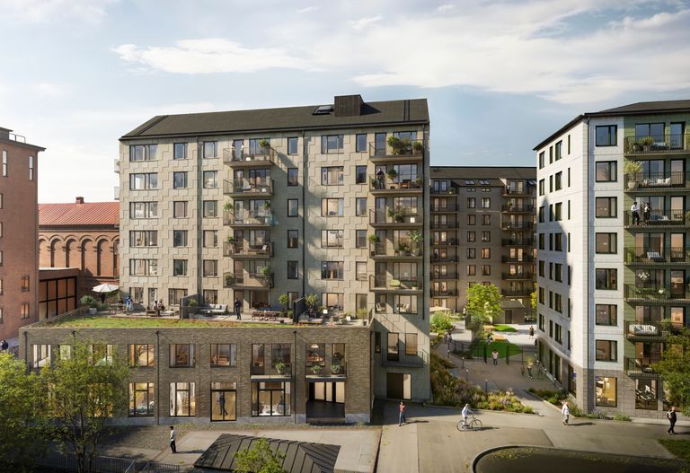 Flerfamiljshus med balkonger, butiker på bottenvåningen och en anlagd innergård en solig dag.