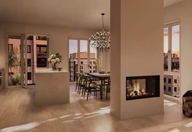 Modern lägenhet med öppen planlösning, matplats, köksö och öppen spis, med utsikt över stadens byggnader i solnedgången.