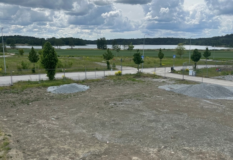 Byggarbetsplats vid Sjöstråket. Utsikt över äng och sjö.