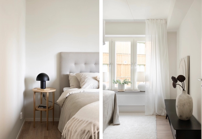 Minimalistiskt sovrum med neutrala toner, en säng, sidobord med lampa, fönster med skira gardiner och enkel inredning.