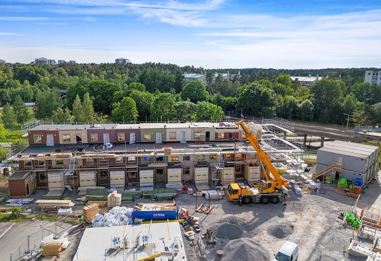 Byggarbetsplats för radhusen Glimten i Råcksta med utsikt över grönskan och tunnelbanan.