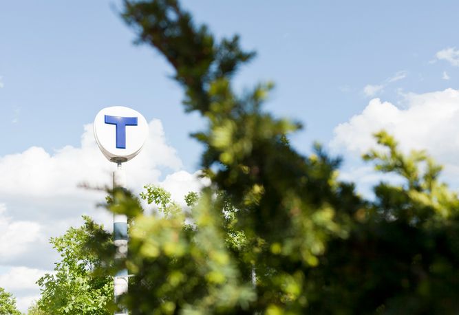 Tunnelbaneskylt med grönska runt om