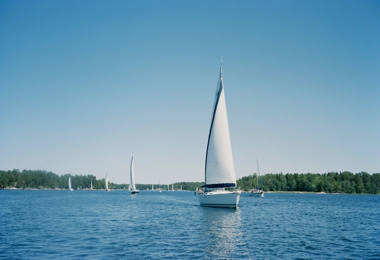 Segelbåt med hissade segel i Stockholms Skärgård.