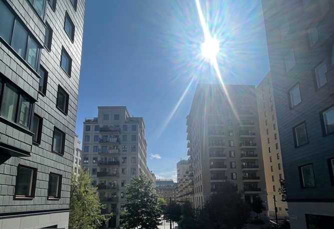 Solig himmel över moderna byggnader i Norra Stationsparken i Hagastaden