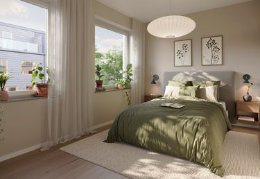 Ljust sovrum med ett grönt överkast, två sängbord och krukväxter på fönsterbrädor.