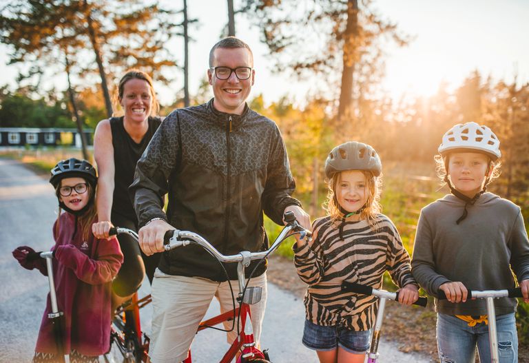 En familj som är ute på cykeltur i skogen.