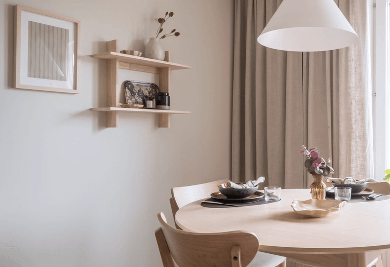 Solbelyst matplats intill ljus vägg med en liten hylla på.