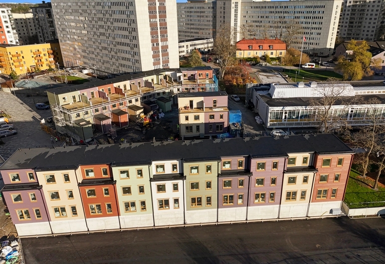 Ett barn som bär ett annat barn på ryggen i en lek på en äng i motljus.