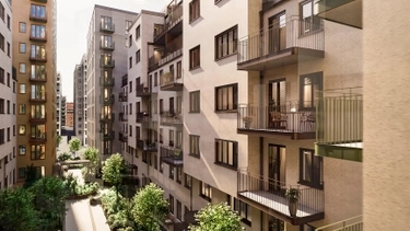 Moderna lägenhetsbyggnader med många balkonger runt en lummig innergård i solsken.