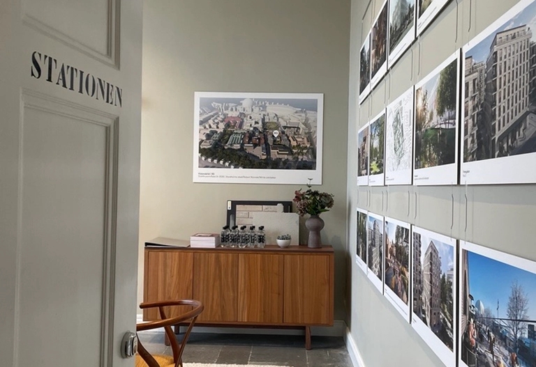 Fransyskans showroom, en rum med ljusa väggar med illustrationsbilder från projektet och området