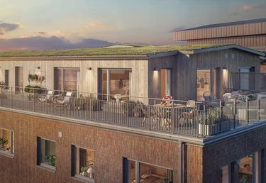 Takterrass med utemöbler och växter på en tegelbyggnad vid solnedgången. 