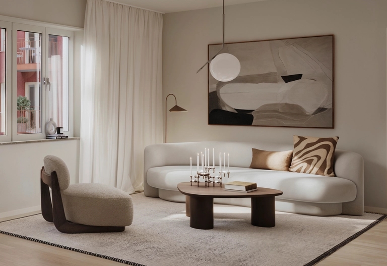 Modernt vardagsrum med vit soffa, abstrakt konst, rund stol, soffbord och stort fönster med skira gardiner.